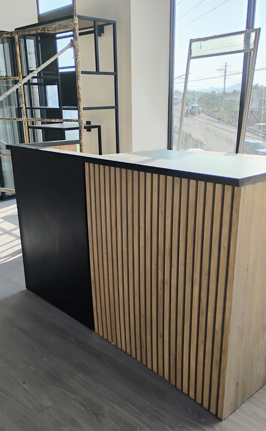 Barra con frente de lamas de madera y módulo negro con cubierta oscura