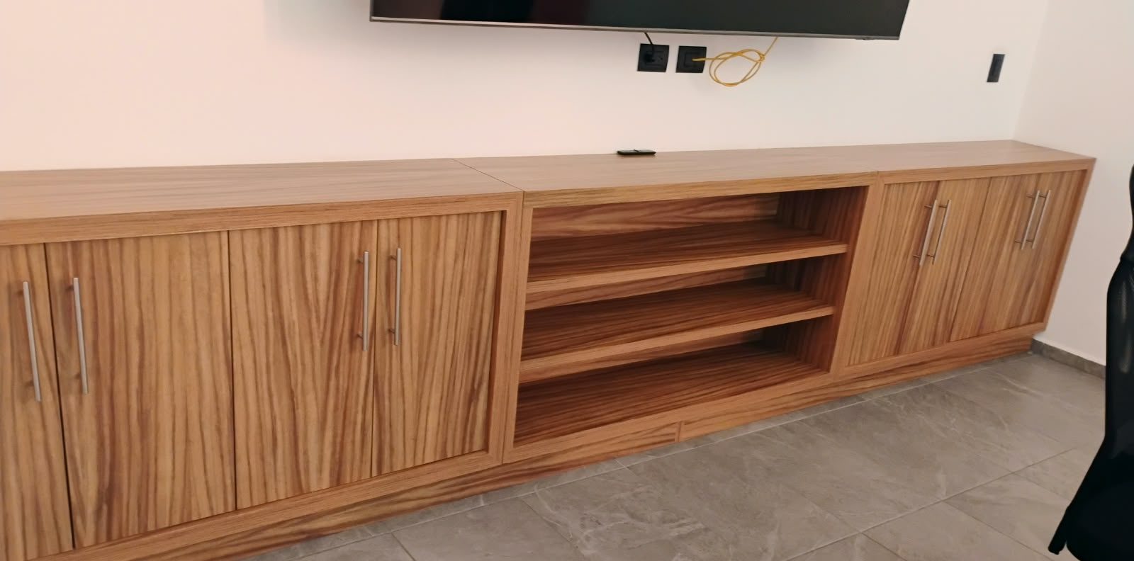 Mueble para sala en madera con veta marcada, entrepaño abierto y puertas con jaladeras